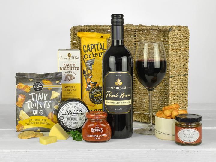 bottle of red wine with savoury snacks and cheese in a gift tray