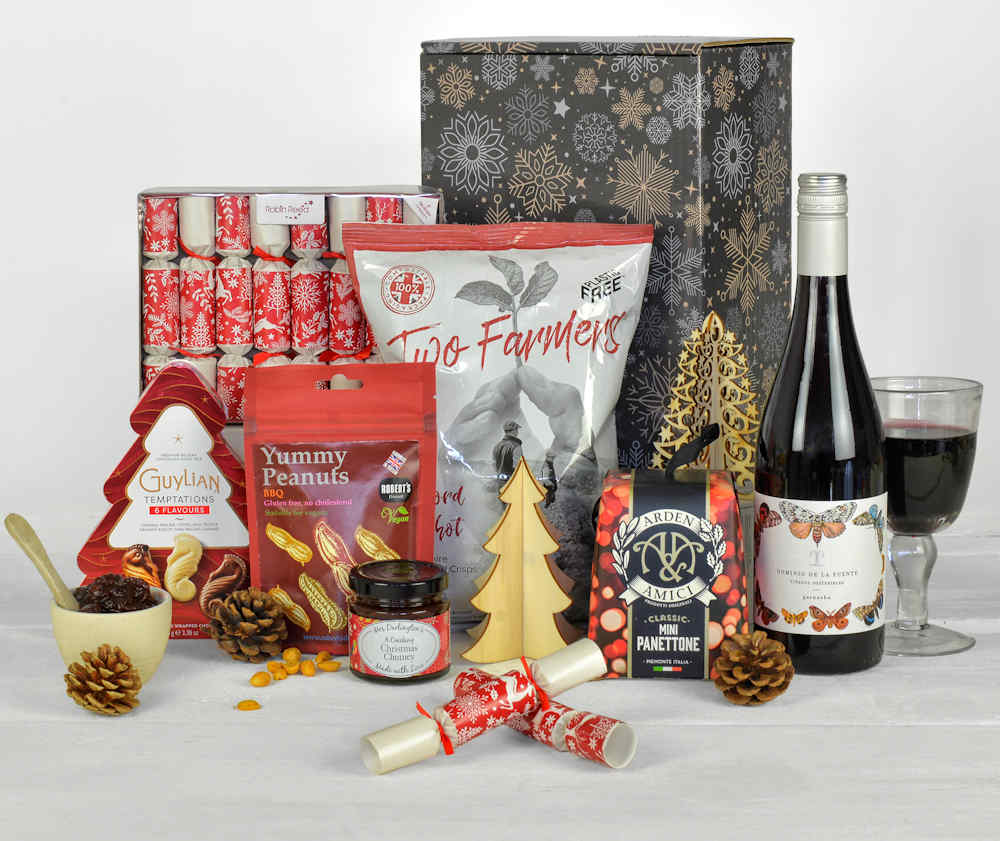 Christmas themed products including a bottle of wine and mini christms crackers in a sustainable gift box