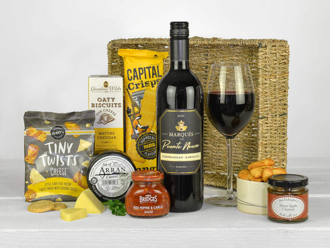 bottle of red wine with savoury snacks and cheese in a gift tray