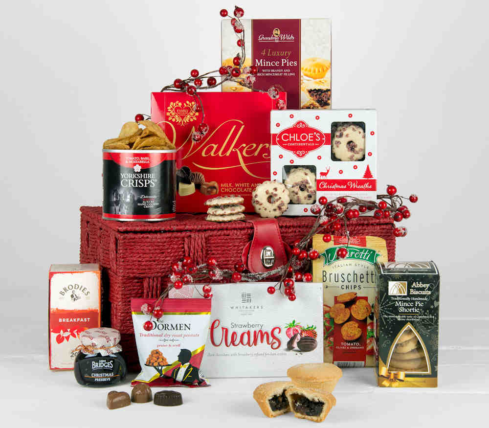 A Red Gift Basket with Christmas mince pies, nuts, preserve, tea, crisps chocolates and other tasty treats