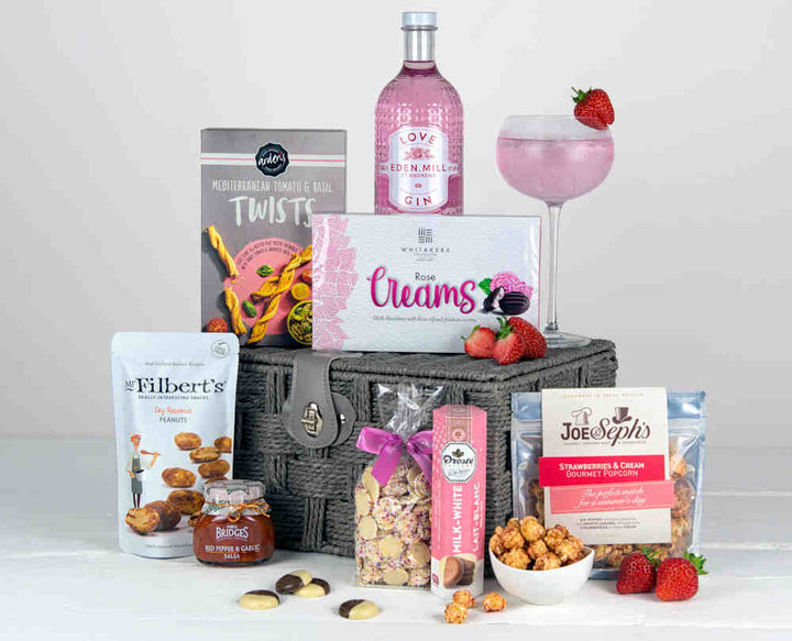 Pink Gin with Rose Creams, popcorn, chocolates and savoury snacks in a grey basket