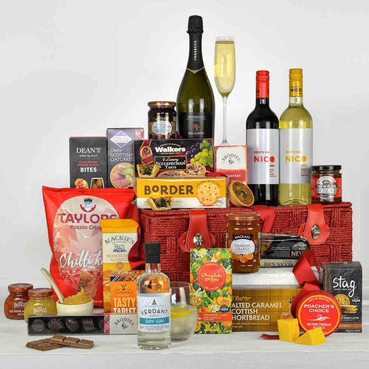 Bottle of prosecco, red and white wine, biscuits, cheesy snacks, chocolate, gin, chutney and other tasty treats all made from Scotland in a Red Paper Rope Gift Basket