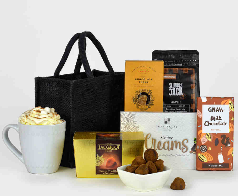Black gift bag with chocolate treats such as hot chocolate, french truffles, chocolate fudge, milk chocolate bar and coffee chocolate creams