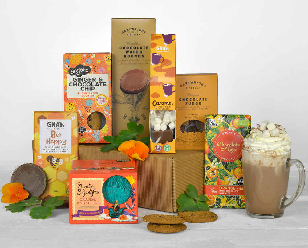 a selection of chocolate products all orange and yellow in colour and made from sustainable companies in a natural gift box