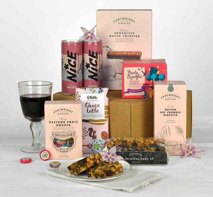 two cans of wine, chocolates , sweets and cake in a natural gift box made from sustainable brands