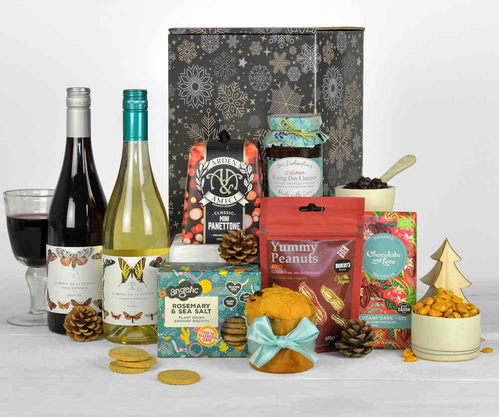 two bottles of wine and christmas panettone, boxing day chutney and other tasty treats all made form sustainable brands in a christmas gift box