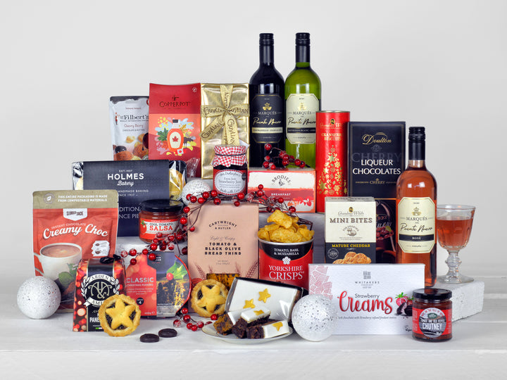 a selection of wines, christmas pudding, mince pies, biscuits, chocolates and other tasty festive food