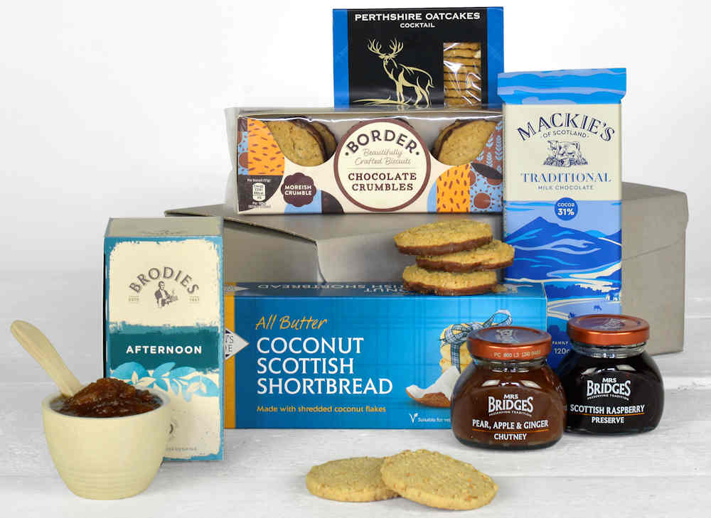 a selection of blue tasty food from Scotland including biscuits, tea, oatcakes and chocolates in a grey gift box